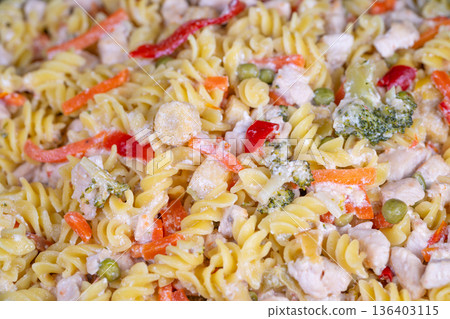 Mixed vegetable pasta preparation ready. Bulk cooked fusilli with vegetables stored for meals. Batch cooked pasta with mixed vegetables for weekly meal planning 136403115