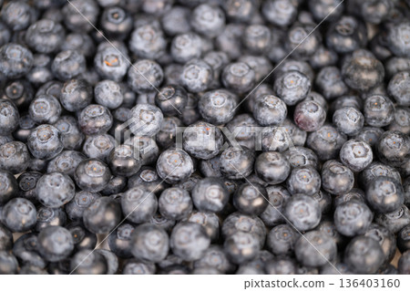 Berry preparation visuals. Vivid closeup of blueberries prepared for baking and blending. Detailed image of blueberries ready for culinary creations and recipe development 136403160