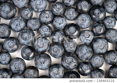Vivid berries with velvety surface. Zoomed image of bright blueberry clusters with powdery coating. Detailed shot capturing vibrant blue hue and soft bloom of berries 136403218
