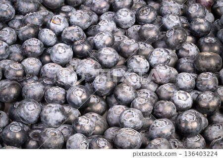 Vivid blue fruits with shiny bloom arranged for culinary presentation. Artisanal dessert ingredients showcasing lustrous blue berries with silver coating on marble background Vivid blue fruits with shiny bloom arranged for culinary presentation. Artisanal dessert ingredients showcasing lustrous blue berries with silver coating on marble background 136403224