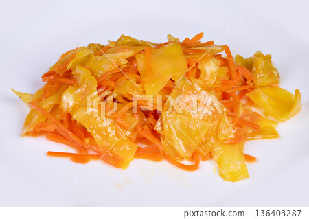 Studioshot vibrant salad with crunchy vegetables and glossy dressing. Stylishly arranged pickled cabbage and carrot salad on white plate demonstrated in studio lighting 136403287