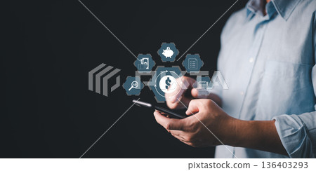 person use smartphone with glow finance icons including dollar symbol, piggy bank, calendar, savings, and analytics, symbolizing digital banking, money management, financial planning, and investment. person use smartphone with glow finance icons including dollar symbol, piggy bank, calendar, savings, and analytics, symbolizing digital banking, money management, financial planning, and investment. 136403293