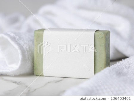 Light green solid soap bar mockup with blank paper label near white bath towel, product packaging Light green solid soap bar mockup with blank paper label near white bath towel, product packaging 136403401
