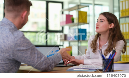 Engaging discussion between colleagues in a bright office space about project progress and future goals during midday work hours Engaging discussion between colleagues in a bright office space about project progress and future goals during midday work hours 136403970