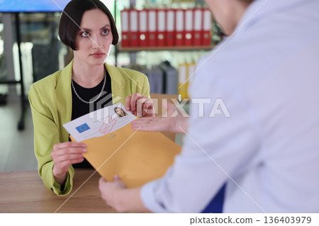 Young woman receiving important documents in a modern office setting during a busy workday Young woman receiving important documents in a modern office setting during a busy workday 136403979