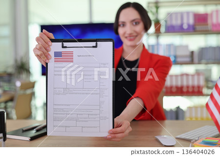 Professional woman showcasing a completed application form in a vibrant office setting during daylight Professional woman showcasing a completed application form in a vibrant office setting during daylight 136404026