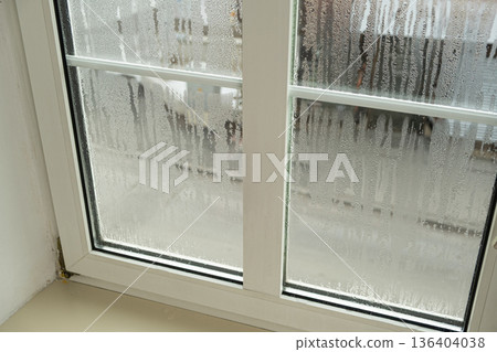 Close up of misted window glass with water streaks and droplets Close up of misted window glass with water streaks and droplets 136404038