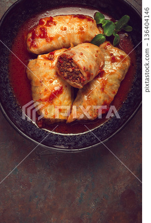 Stuffed cabbage rolls with minced meat, in tomato sauce, top view, without people, in the spotlight. 136404146