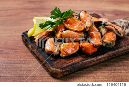 mussels without shell, boiled, mussels, peeled, on a chopping board, with lemon and parsley, mussels in Chilean, top view, no people, 136404156