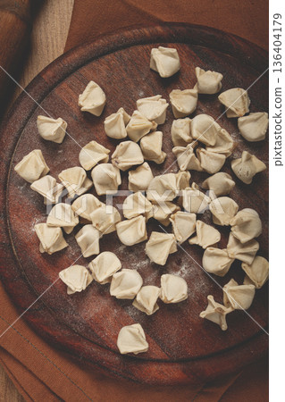 Traditional Turkish dumplings,raw, on a cutting board, top view, no people, 136404179