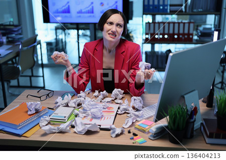 Frustration mounts as a woman battles paperwork chaos in a busy modern office during a productive workday Frustration mounts as a woman battles paperwork chaos in a busy modern office during a productive workday 136404213