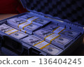 Stacks of new hundred dollar bills neatly arranged in a sturdy case, showcasing wealth and opportunity in a cozy setting 136404245