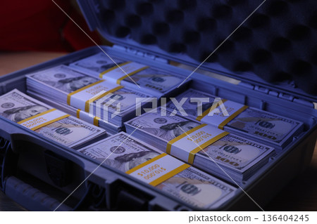 Stacks of new hundred dollar bills neatly arranged in a sturdy case, showcasing wealth and opportunity in a cozy setting Stacks of new hundred dollar bills neatly arranged in a sturdy case, showcasing wealth and opportunity in a cozy setting 136404245