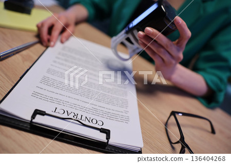 Signing important documents in a cozy office atmosphere during the afternoon hours Signing important documents in a cozy office atmosphere during the afternoon hours 136404268