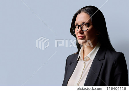 Profile view of serious confident business woman, gray background, copy space Profile view of serious confident business woman, gray background, copy space 136404316