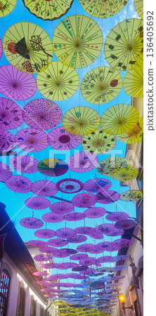 Multi-colored umbrellas background. Colorful umbrellas floating above the street. Street decoration. 136405692