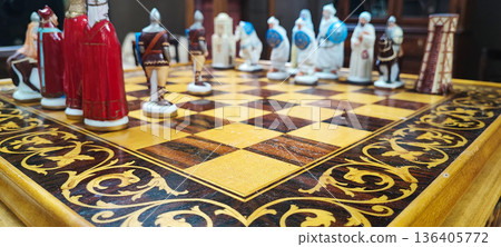 A close-up of a decorative chessboard with detailed medieval-style pieces. Conceptual representation of leadership, competition, decision-making, business strategy, and critical thinking. A close-up of a decorative chessboard with detailed medieval-style pieces. Conceptual representation of leadership, competition, decision-making, business strategy, and critical thinking. 136405772