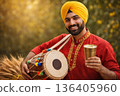 Man celebrating Baisakhi festival with dhol drum, wheat and lassi drink in Punjab. 136405960