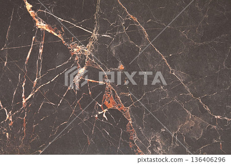 Striking black marble surface adorned with golden and white veins in natural elegance 136406296
