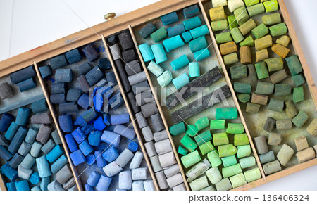 Wooden box containing a set of soft pastel crayons for an artist, top view. Broken sticks for drawing and painting Wooden box containing a set of soft pastel crayons for an artist, top view. Broken sticks for drawing and painting 136406324