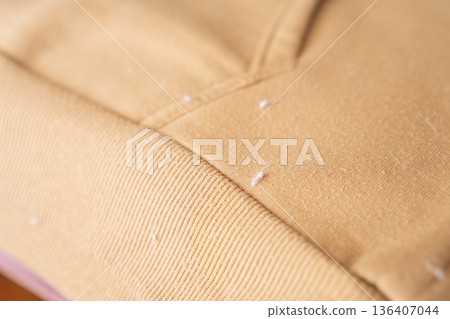 Close-up of sweatshirt hoodie pilling before fabric care process removing lint and fuzz using an electric fabric shaver restoring garment appearance and texture. Close-up of sweatshirt hoodie pilling before fabric care process removing lint and fuzz using an electric fabric shaver restoring garment appearance and texture. 136407044