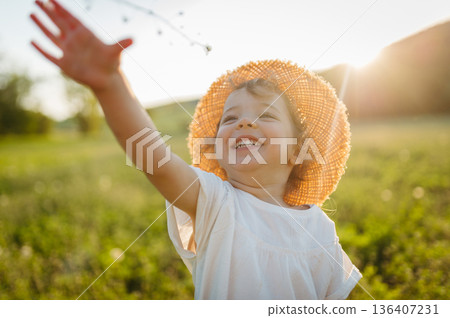 Cute girl playing on meadow, in nauture. Cute girl playing on meadow, in nauture. 136407231