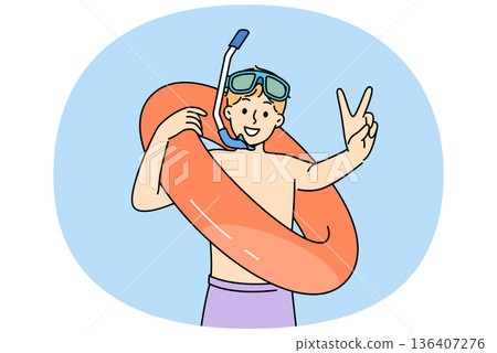 Little boy who loves to swim in pool with inflatable ring shows V gesture and looks at screen 136407276