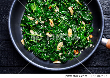 Flat lay of cooked spinach mixed with roasted garlic Flat lay of cooked spinach mixed with roasted garlic 136407414