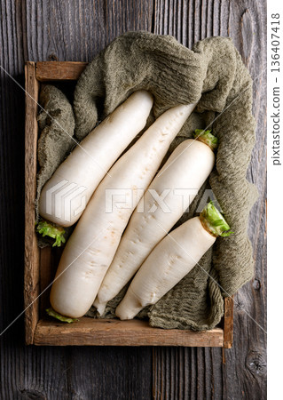 Fresh daikon radish in wooden box with fabric Fresh daikon radish in wooden box with fabric 136407418