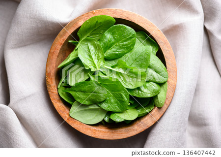 Top view of organic spinach leaves in wooden bowl 136407442