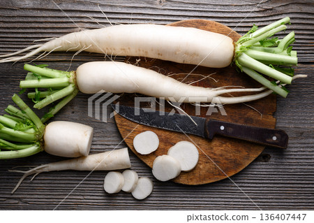 Whole and sliced daikon radish on wooden background Whole and sliced daikon radish on wooden background 136407447