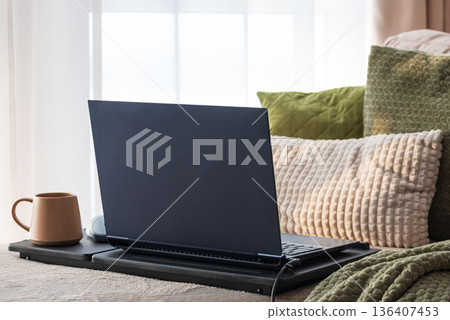 Laptop and Coffee Mug on Lap Desk. Cozy Morning Home Workspace with Green Accents 136407453