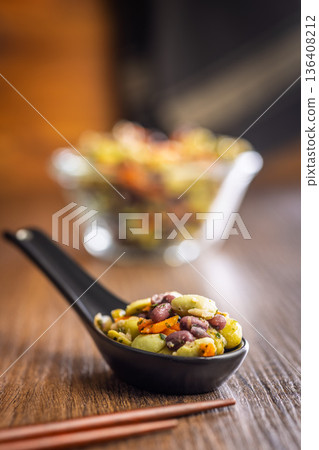 Fresh salad with edamame beans in ceramic spoon on wooden table. Fresh salad with edamame beans in ceramic spoon on wooden table. 136408212