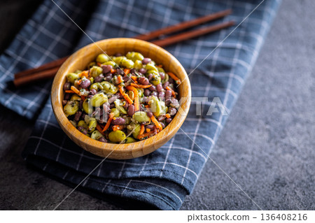 Fresh salad with edamame beans in bowl on black table. Fresh salad with edamame beans in bowl on black table. 136408216