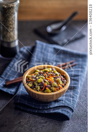 Fresh salad with edamame beans in bowl on black table. Fresh salad with edamame beans in bowl on black table. 136408218