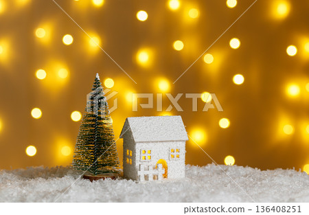 Christmas wooden houses garlands with lights in the snow on glowing lights bokeh background 136408251