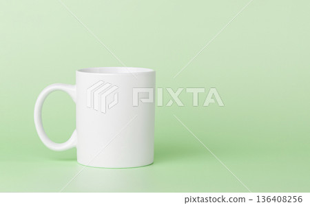 white cup for tea or coffee on a green background 136408256