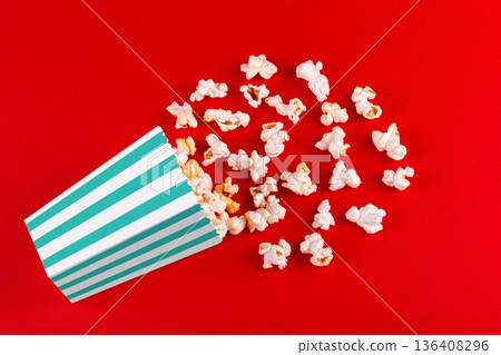 box with popcorn striped in different colors on a red background 136408296