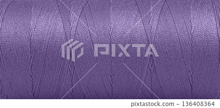Texture of threads in a spool of purple color on a white background 136408364