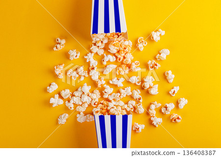 cardboard box with popcorn on a yellow background cardboard box with popcorn on a yellow background 136408387
