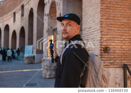 Traveler with Action Camera Exploring Ancient Roman Architecture in Rome, Italy 136408530
