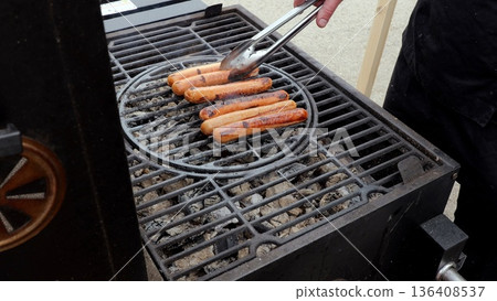 Grilled sausage gathering, Summer barbecue with flavorful links, Outdoor cookout featuring sizzling links and warm atmosphere, Enjoying summer evenings with roasted sausages and lively grilling 136408537