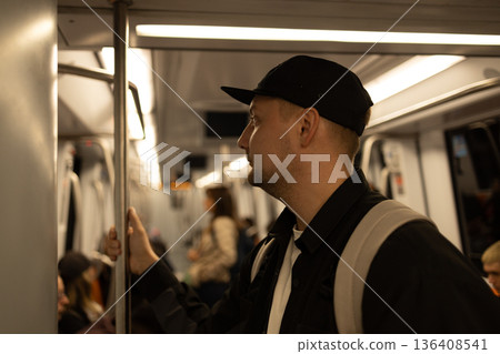 Man standing inside a subway train holding a handrail while commuting on public transportation in Rome  136408541