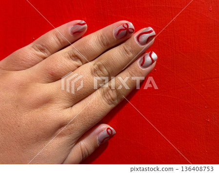 Elegant red and silver manicure on female hand 136408753