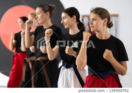 Women in a fighting stance during training 136408762