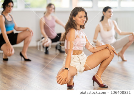 Expressive young girl partaking in group sass dance class Expressive young girl partaking in group sass dance class 136408821