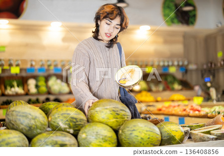 Girl shopping in vegetable store and buy elect melon 136408856