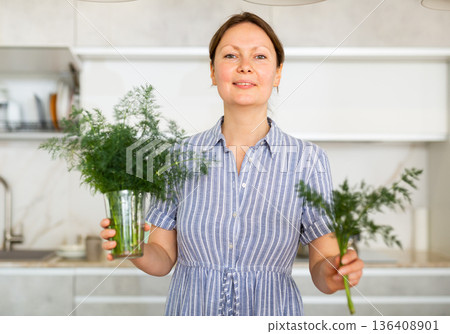 Woman took out small sprig of dill weed fennel from large bunch of greenery Woman took out small sprig of dill weed fennel from large bunch of greenery 136408901
