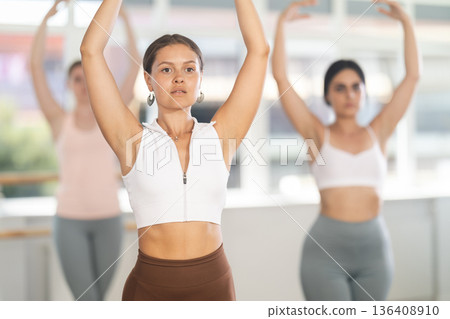 Close-up view of young girl practicing ballet positions standing in row 136408910