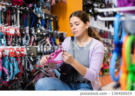 Young cheerful woman buying cat harness in pet store Young cheerful woman buying cat harness in pet store 136408929